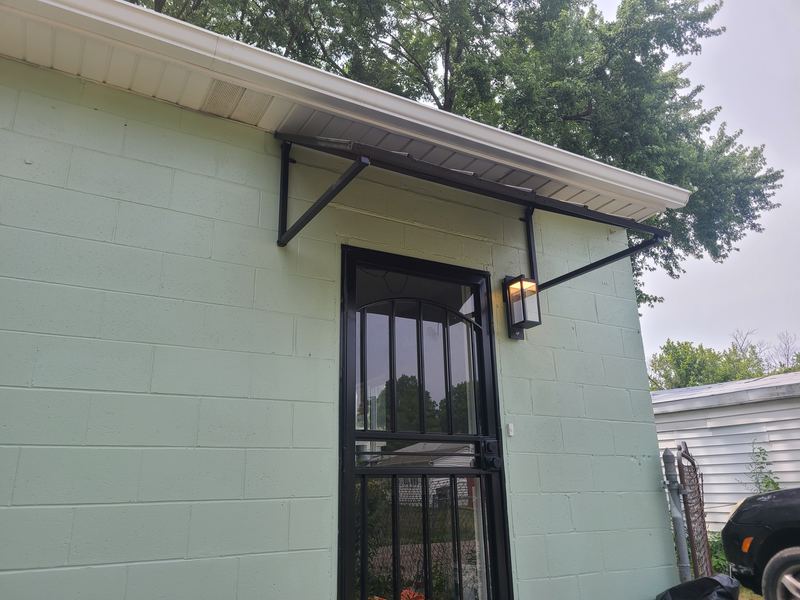 Exterior entry door with a security door and a small awning
